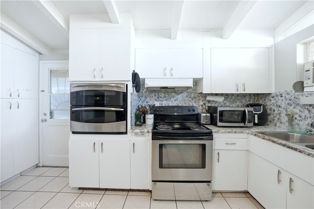 10909 1st Whittier, CA 90603 - Photo 11 of 30 a kitchen with stainless steel appliances a stove top oven and cabinets