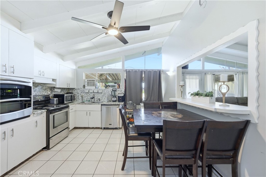 10909 1st Whittier, CA 90603 - Photo 8 of 30 a kitchen with a dining table chairs stainless steel appliances and cabinets