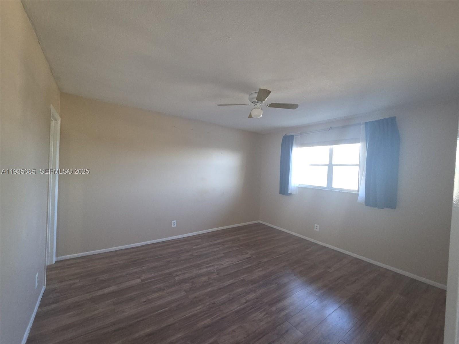 8020 North Colony Circle, Unit 305 Tamarac, FL 33321 - Photo 13 of 19 a view of an empty room with wooden floor and a window