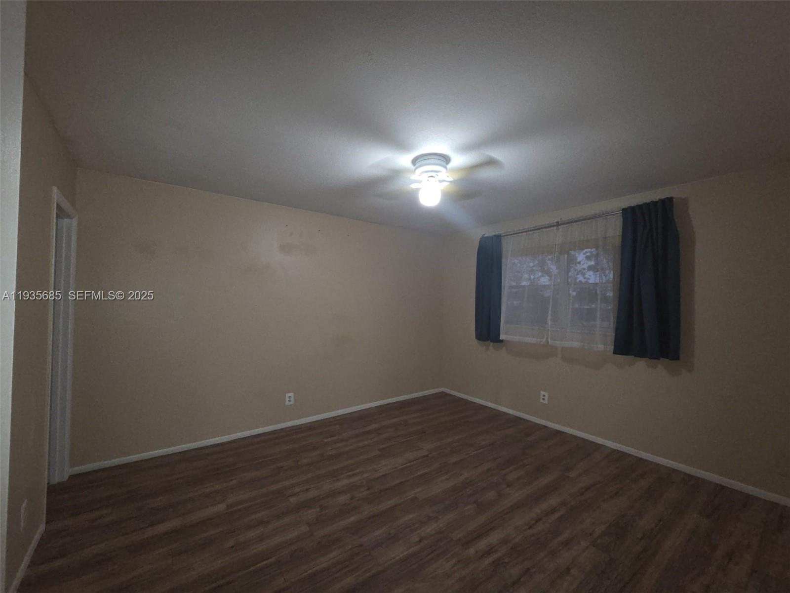 8020 North Colony Circle, Unit 305 Tamarac, FL 33321 - Photo 15 of 19 an empty room with wooden floor and windows