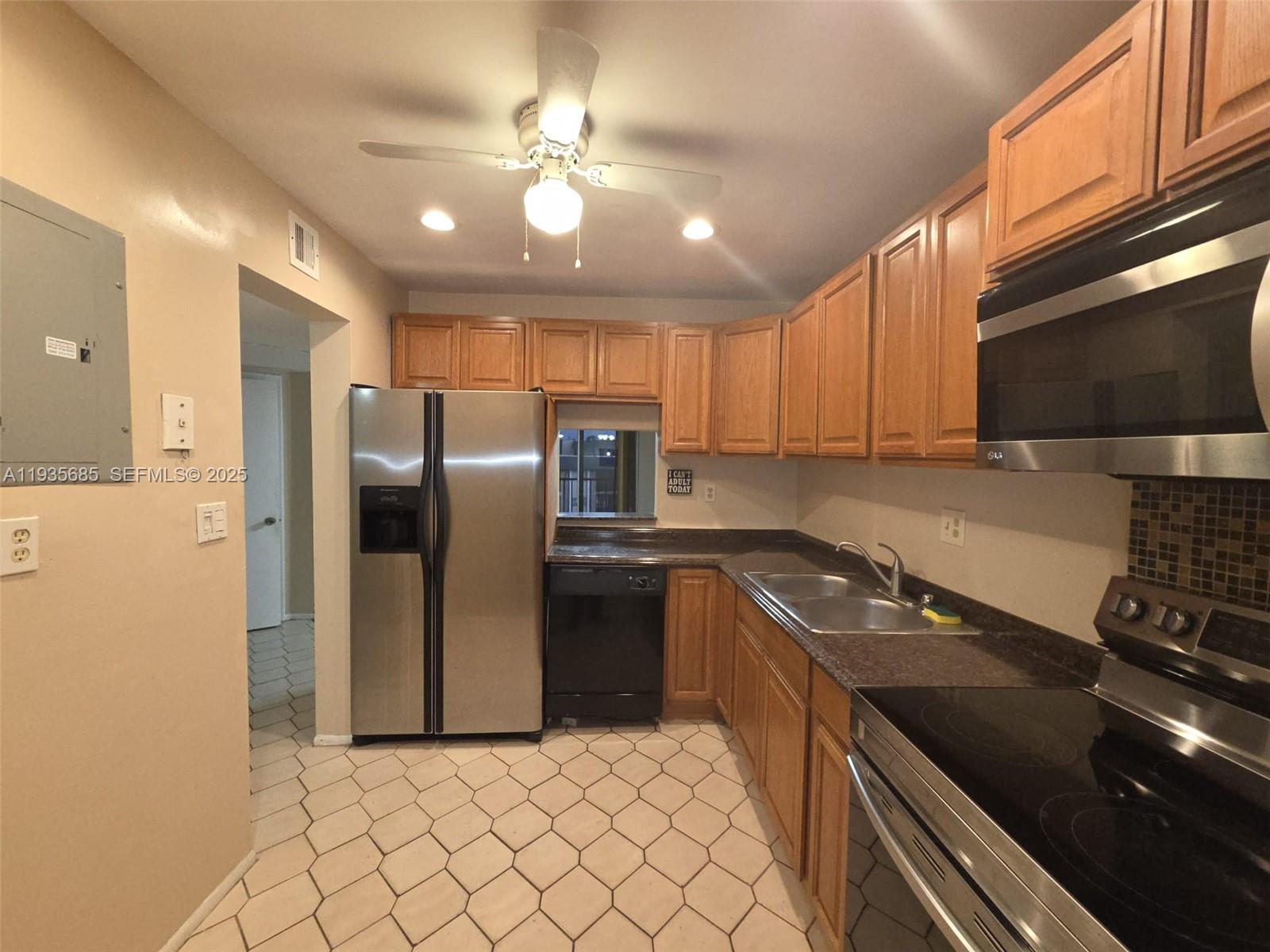 8020 North Colony Circle, Unit 305 Tamarac, FL 33321 - Photo 6 of 19 a kitchen with stainless steel appliances granite countertop a sink a stove a refrigerator a washer dryer and cabinets