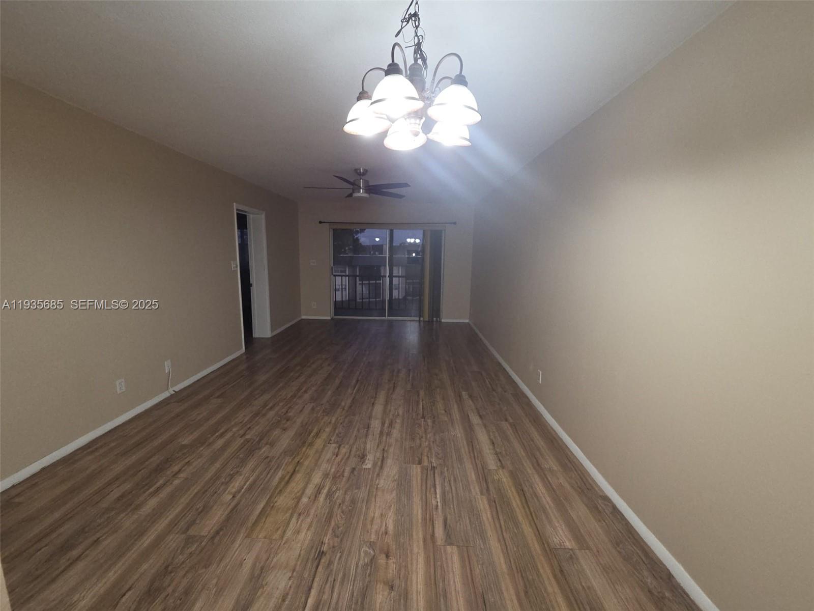 8020 North Colony Circle, Unit 305 Tamarac, FL 33321 - Photo 7 of 19 a view of wooden floor and a chandelier in a room