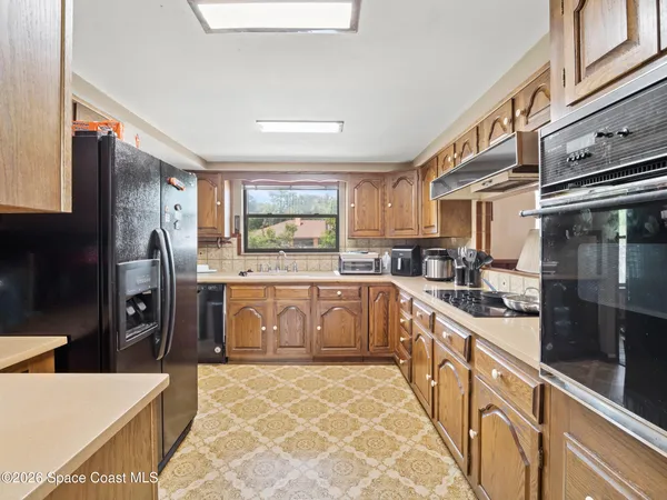 a large kitchen with stainless steel appliances kitchen island granite countertop a refrigerator and a stove top oven