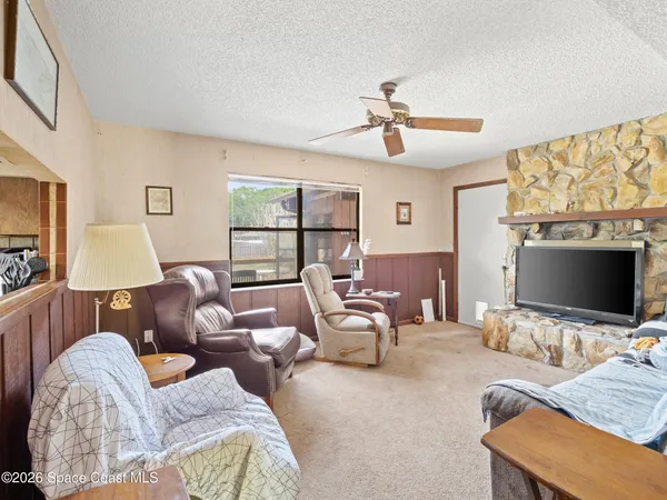 a living room with furniture a flat screen tv and a window