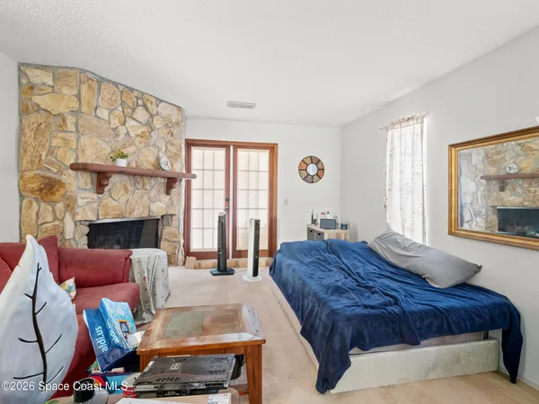 a spacious bedroom with a bed a couch and large window