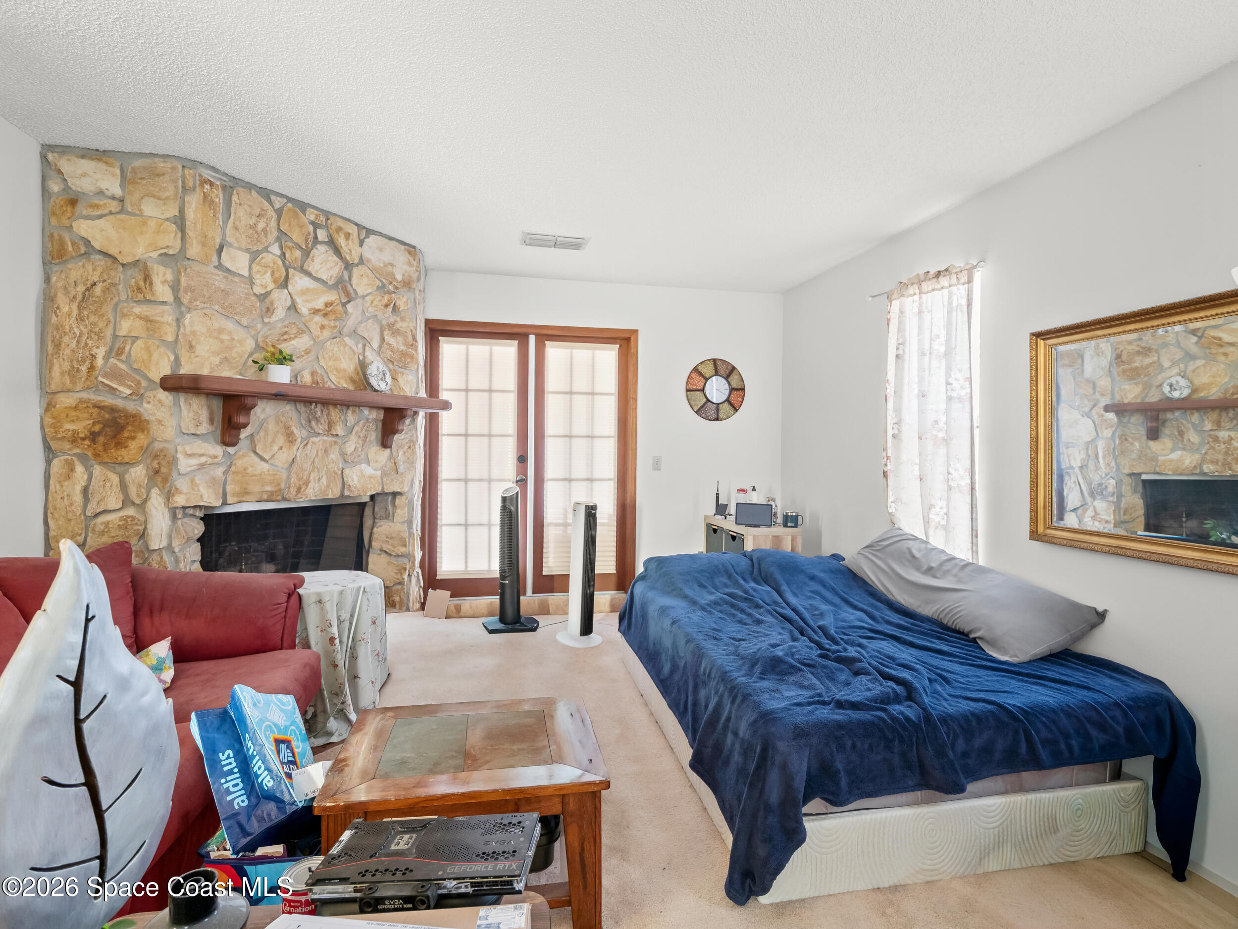 1190 Shady Lane Merritt Island, FL 32952 - Photo 8 of 35 a spacious bedroom with a bed a couch and large window