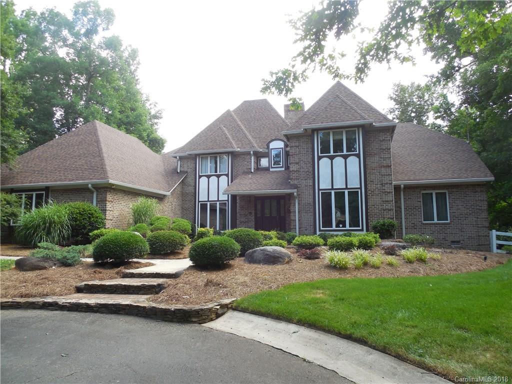 a front view of a house with a yard and potted plants