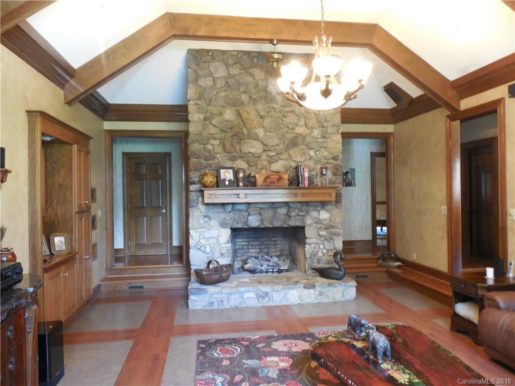 930 Shive Road Salisbury, NC 28146 - Photo 10 of 36 a living room with a fireplace a flat screen tv and a chandelier