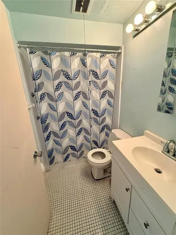 a bathroom with a sink a toilet and shower curtain