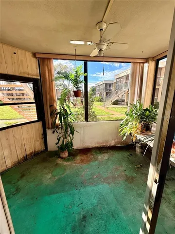 a living room with patio furniture and a potted plant
