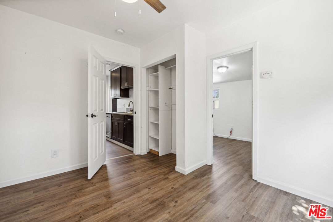 3110 Pyrites Street Los Angeles, CA 90032 - Photo 19 of 30 an empty room with wooden floor and way to kitchen