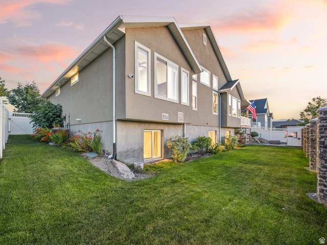 7 Sterling Loop Vineyard, UT 84059 - Photo 40 of 43 Exterior stucco siding with multiple windows and a white vinyl fence