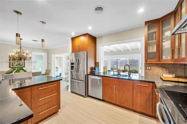 a kitchen with stainless steel appliances kitchen island granite countertop a refrigerator and a stove top oven