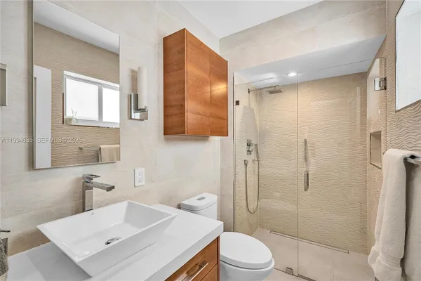 a bathroom with a sink toilet vanity and shower