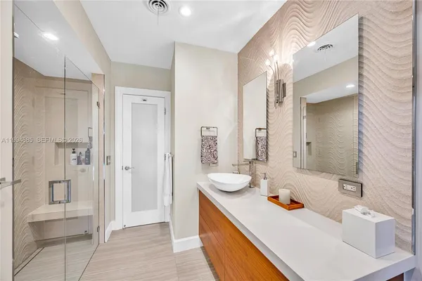 a bathroom with a tub sink and mirror