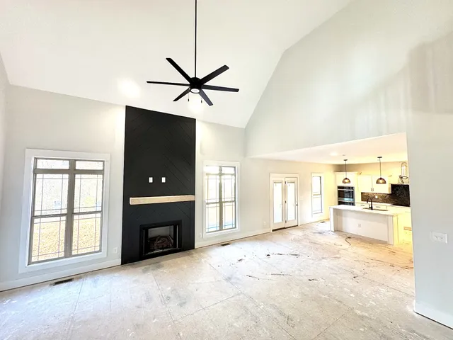 an empty room with a window and a fan