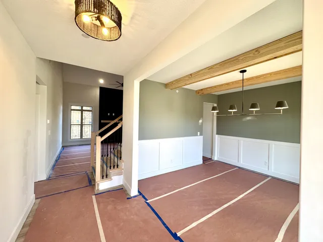an empty room with ceiling fan and windows