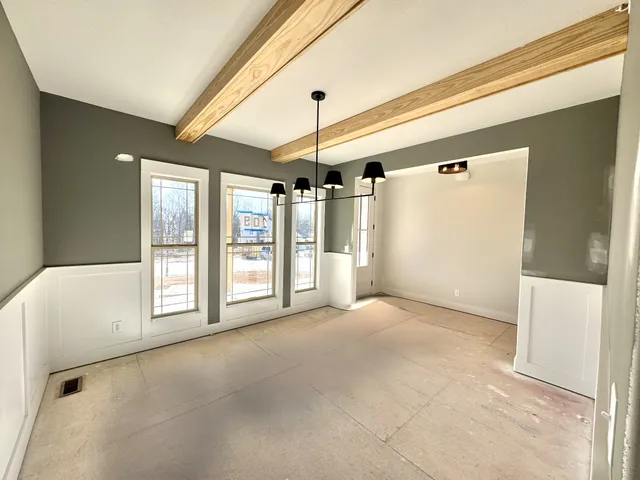 an empty room with a window and a fan