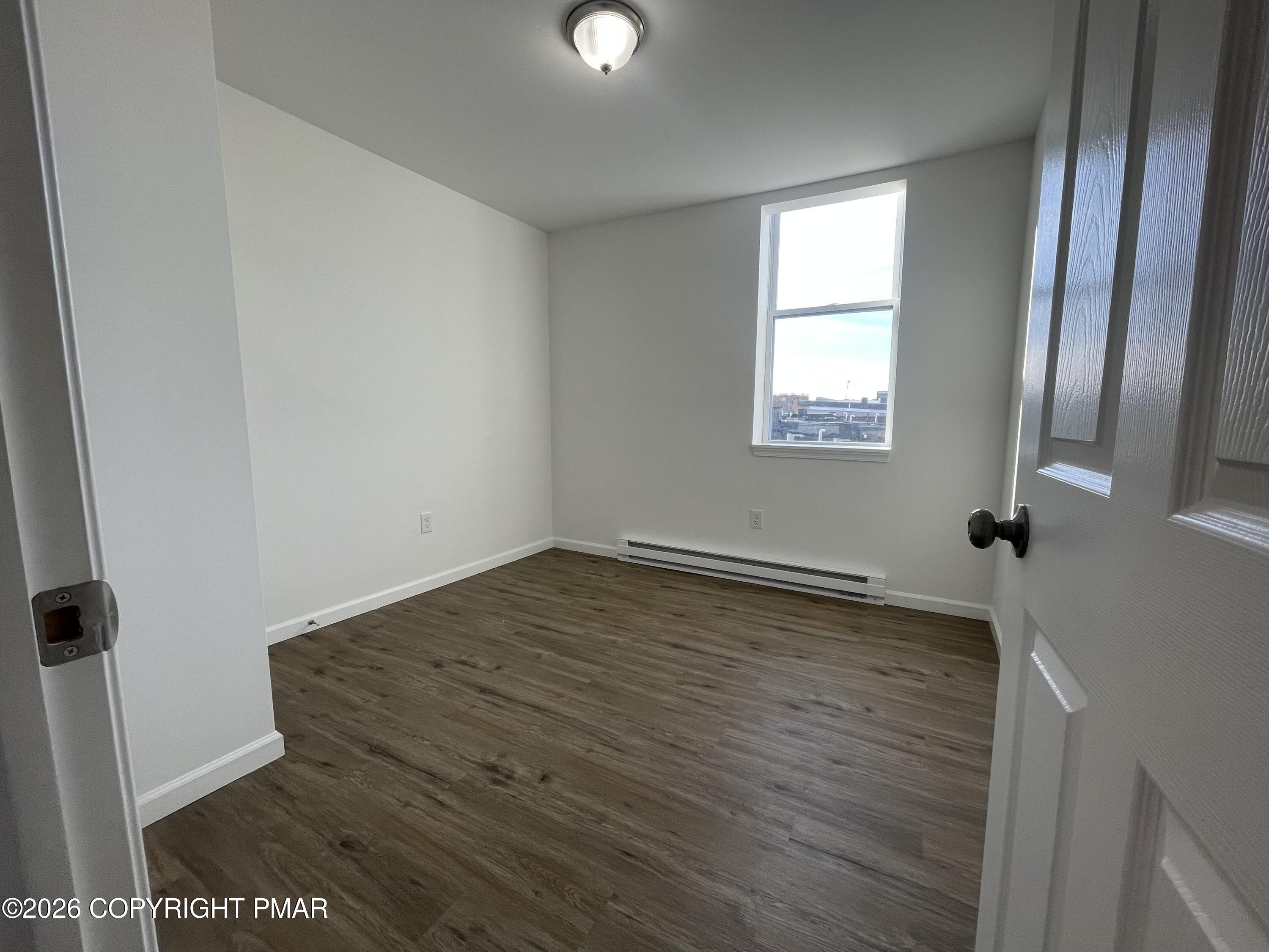 548 Main Street, Unit 6B Stroudsburg, PA 18360 - Photo 2 of 16 an empty room with wooden floor and windows