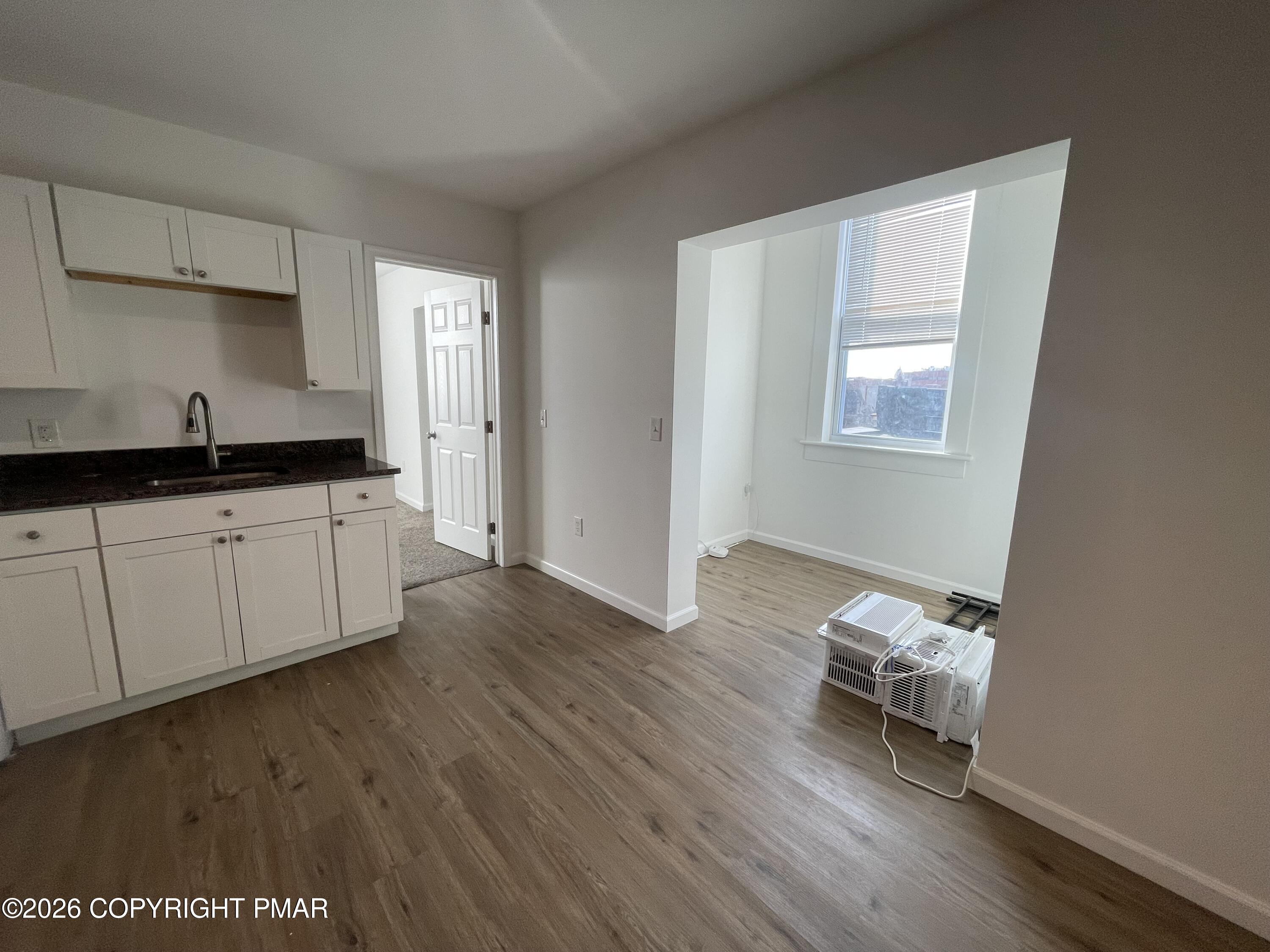 548 Main Street, Unit 6B Stroudsburg, PA 18360 - Photo 9 of 16 a kitchen with granite countertop a sink cabinets and wooden floor