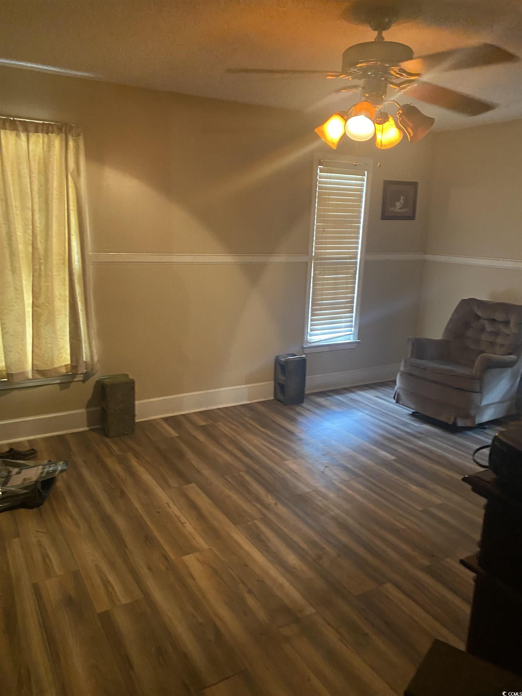 708 Grices Ferry Mullins, SC 29574 - Photo 4 of 13 Unfurnished room featuring ceiling fan and dark hardwood / wood-style flooring