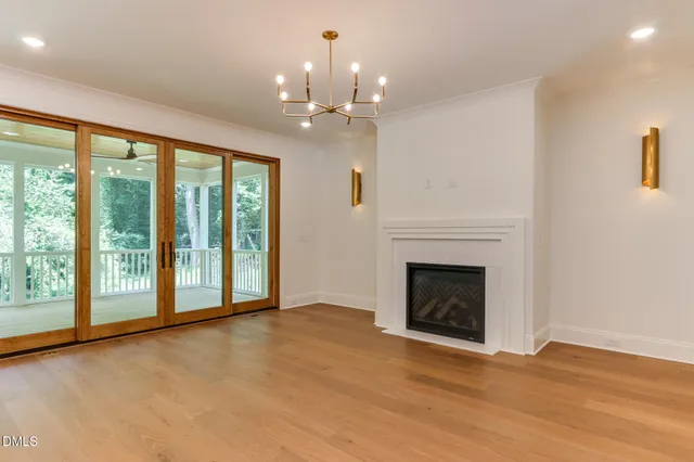 a view of an empty room with a fireplace and a window