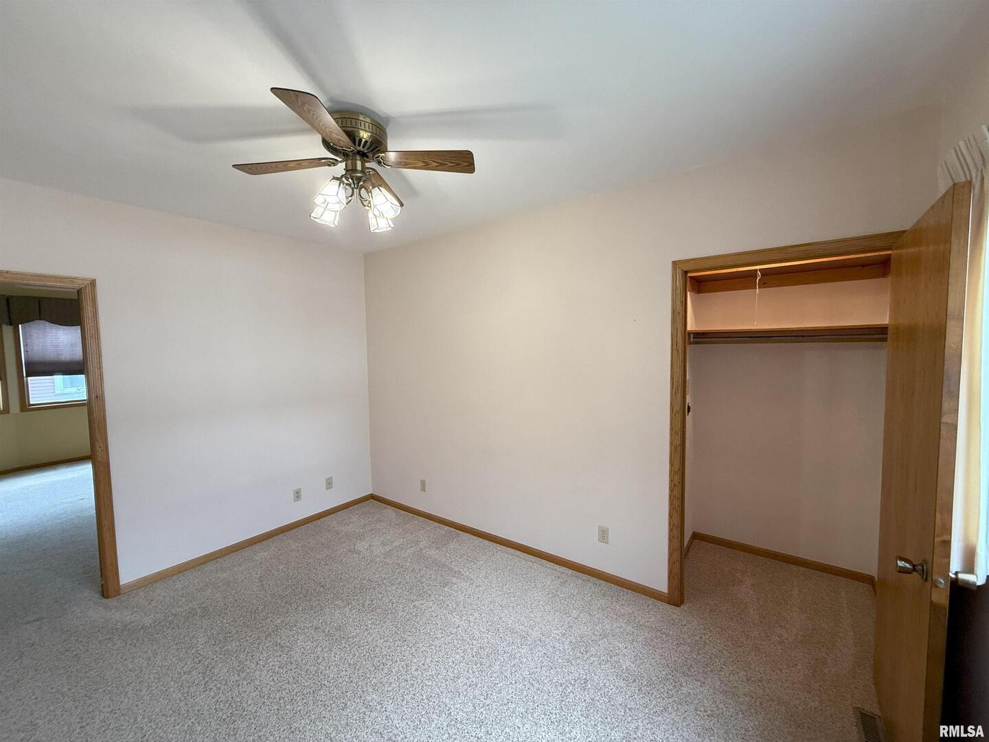 330 North Main Street Walcott, IA 52773 - Photo 11 of 39 an empty room with closet and a ceiling fan