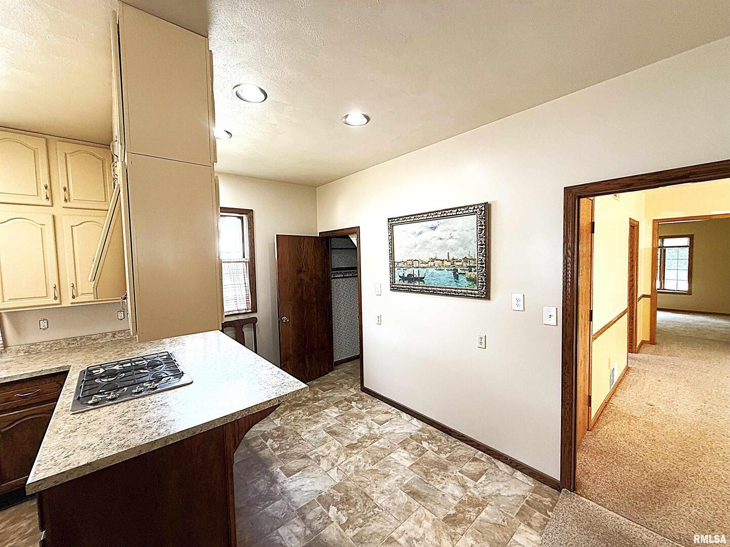 330 North Main Street Walcott, IA 52773 - Photo 14 of 39 a view of a kitchen with refrigerator and wooden floor