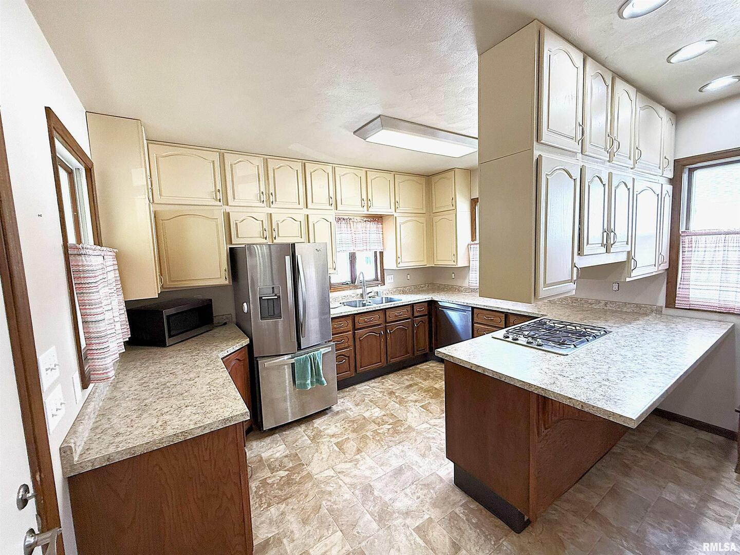 330 North Main Street Walcott, IA 52773 - Photo 15 of 39 a kitchen with stainless steel appliances granite countertop a sink stove and refrigerator