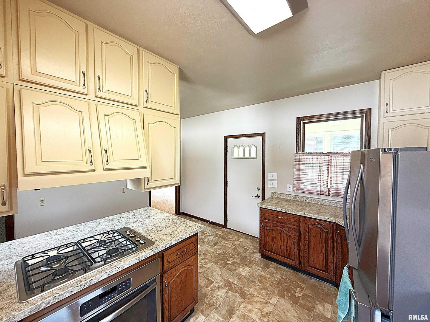 330 North Main Street Walcott, IA 52773 - Photo 16 of 39 a kitchen with stainless steel appliances granite countertop a stove a refrigerator and a cabinets