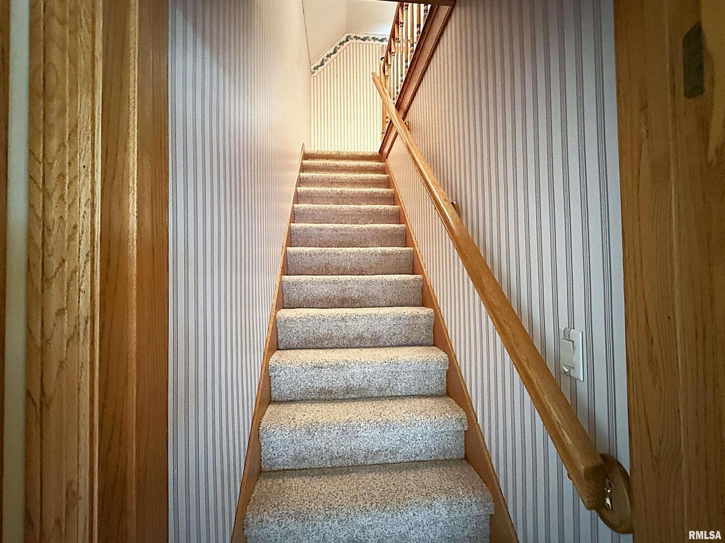 330 North Main Street Walcott, IA 52773 - Photo 18 of 39 a view of staircase with lots of frames on wall
