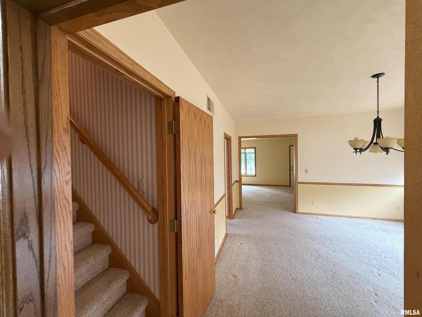 330 North Main Street Walcott, IA 52773 - Photo 19 of 39 a view of a hallway with wooden floor and staircase