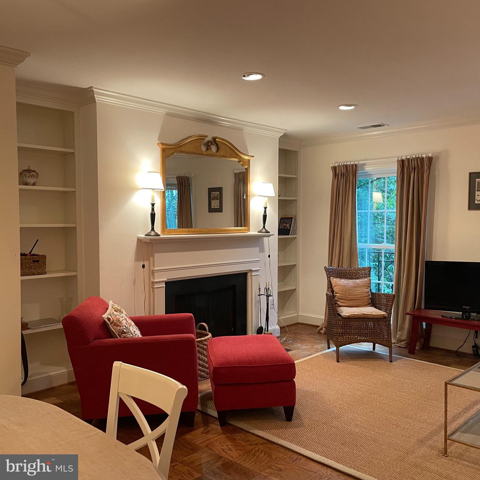 3221 Sutton Place Northwest, Unit B Washington, DC 20016 - Photo 3 of 22 a living room with furniture a fireplace and a flat screen tv