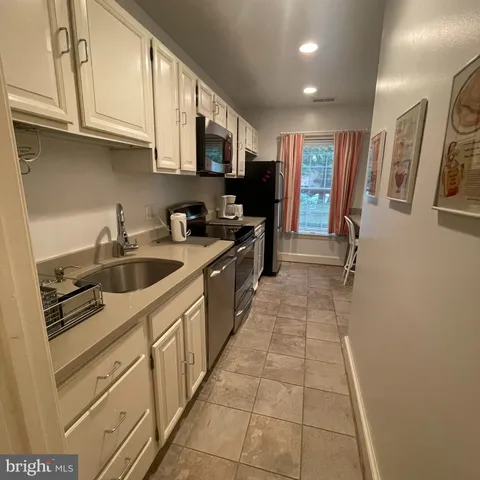 a kitchen with stainless steel appliances granite countertop a refrigerator and a sink