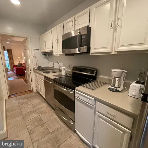 a kitchen with stainless steel appliances granite countertop a sink and a stove