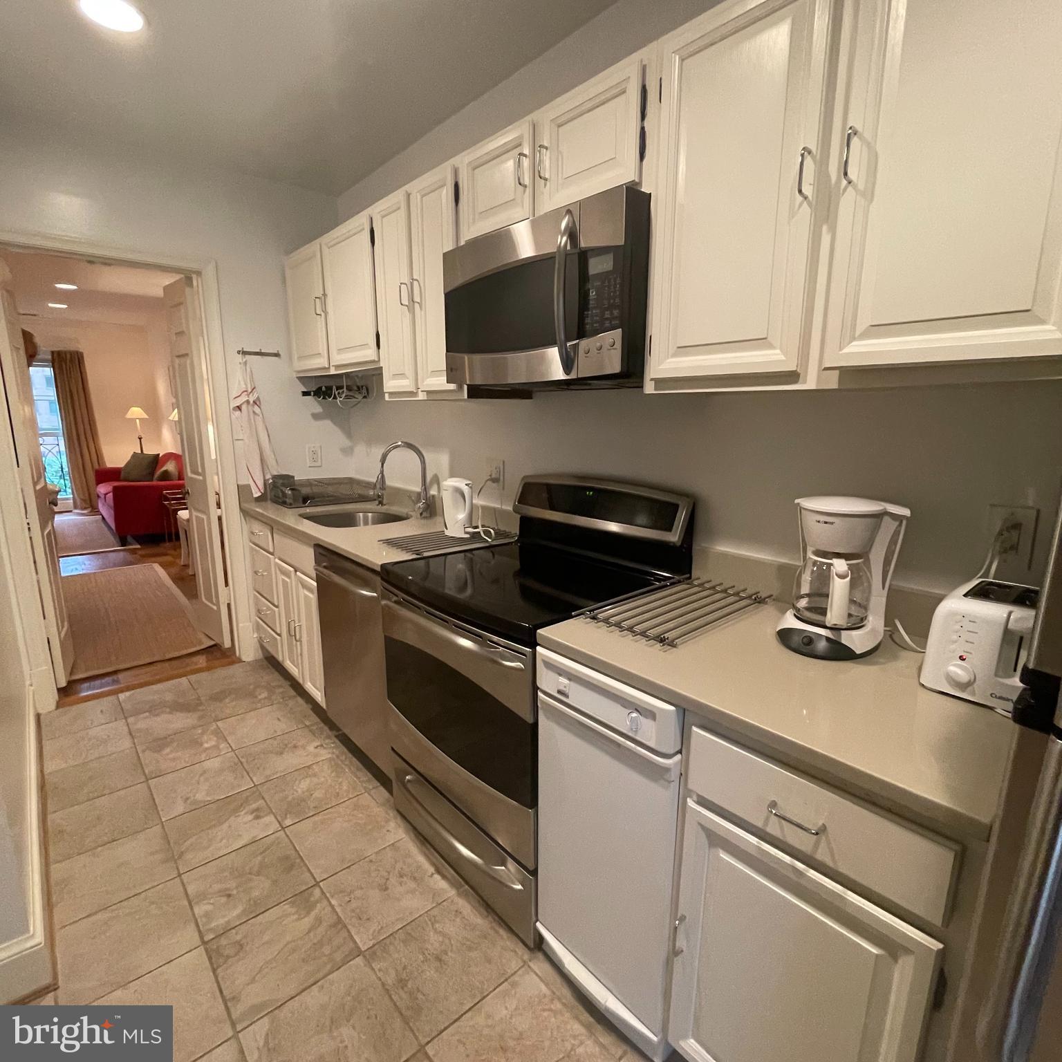 3221 Sutton Place Northwest, Unit B Washington, DC 20016 - Photo 9 of 22 a kitchen with stainless steel appliances granite countertop a sink and a stove