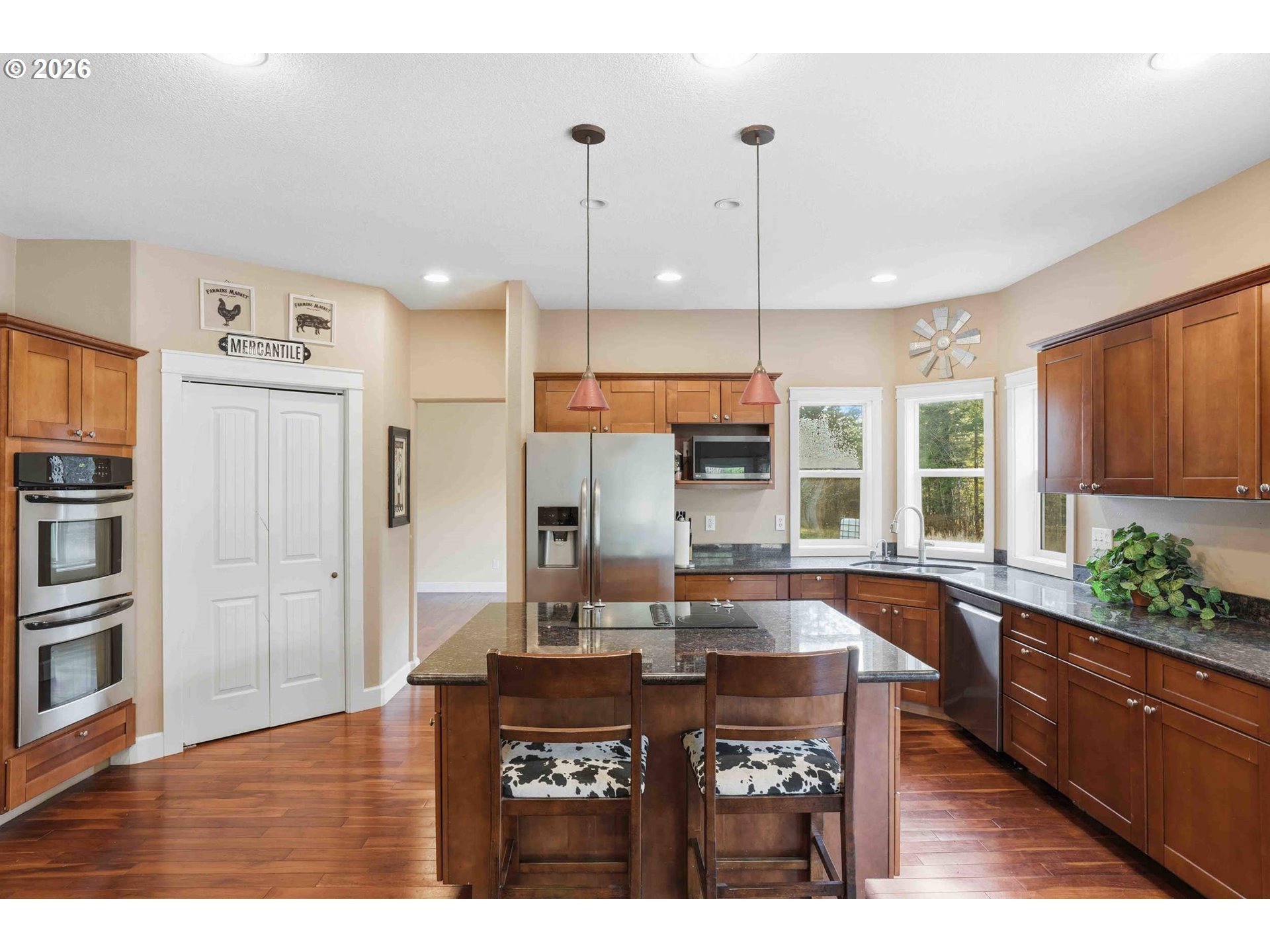 4204 Northeast Cardiel Road Washougal, WA 98671 - Photo 11 of 42 a kitchen with stainless steel appliances kitchen island granite countertop a refrigerator a sink and wooden floors