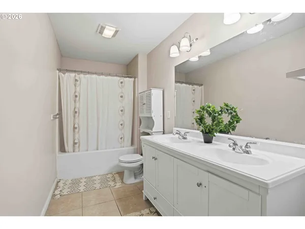 a bathroom with a sink a toilet a large mirror and shower