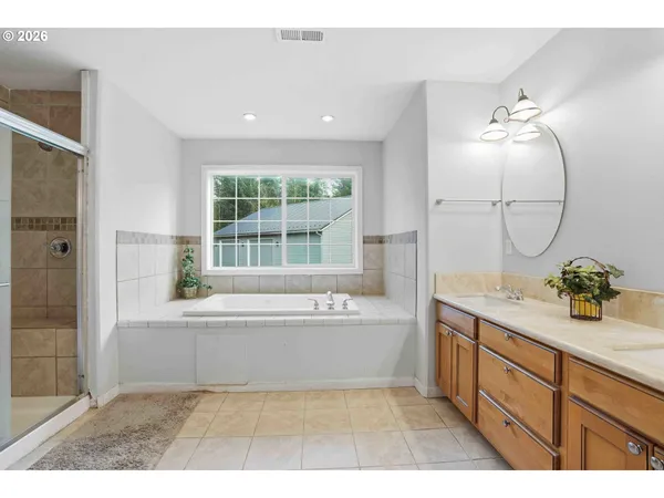 a bathroom with a tub sink and mirror