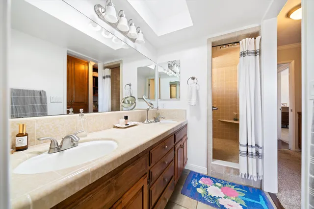 a spacious bathroom with a double vanity sink mirror and shower