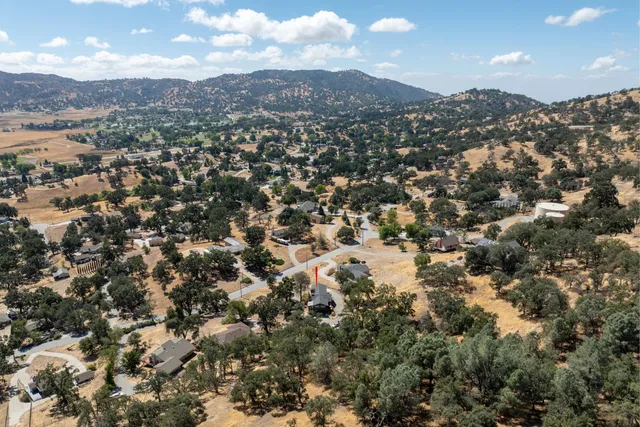 an aerial view of residential houses with outdoor space and mountain view