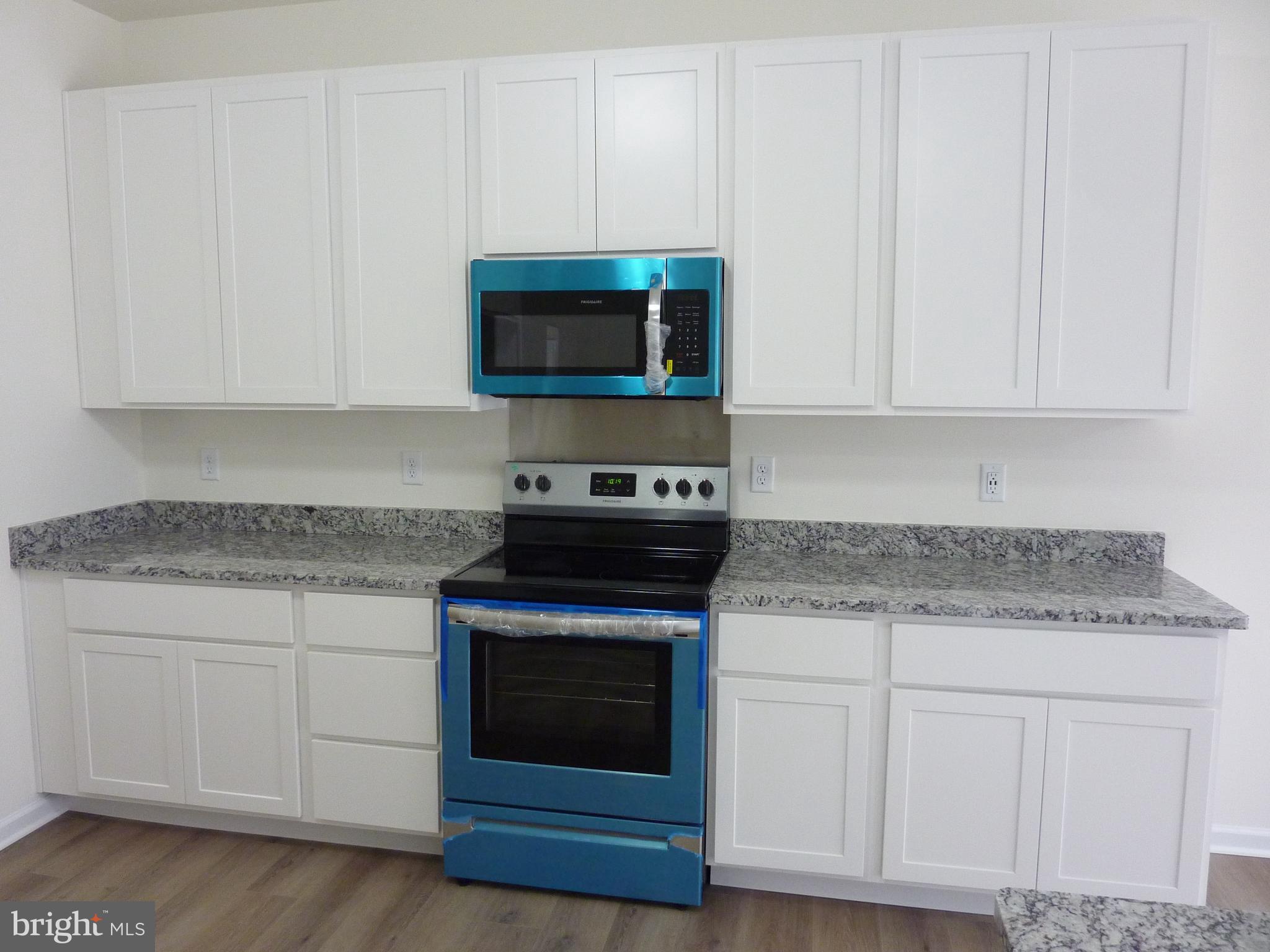 175 Villa Drive Clayton, DE 19938 - Photo 11 of 44 a kitchen with granite countertop white cabinets and stainless steel appliances