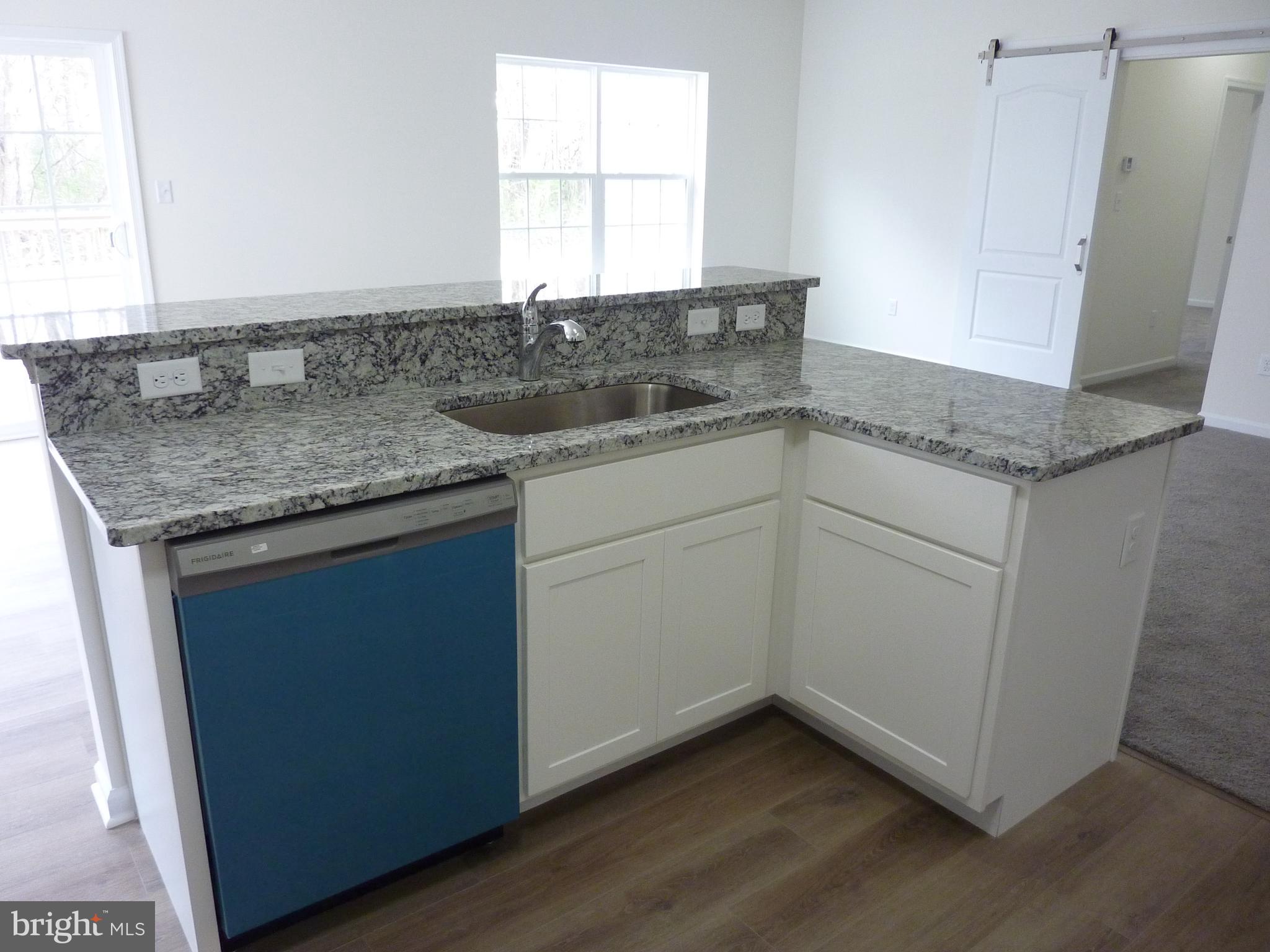 175 Villa Drive Clayton, DE 19938 - Photo 12 of 44 a kitchen with granite countertop cabinets stainless steel appliances a sink and a window