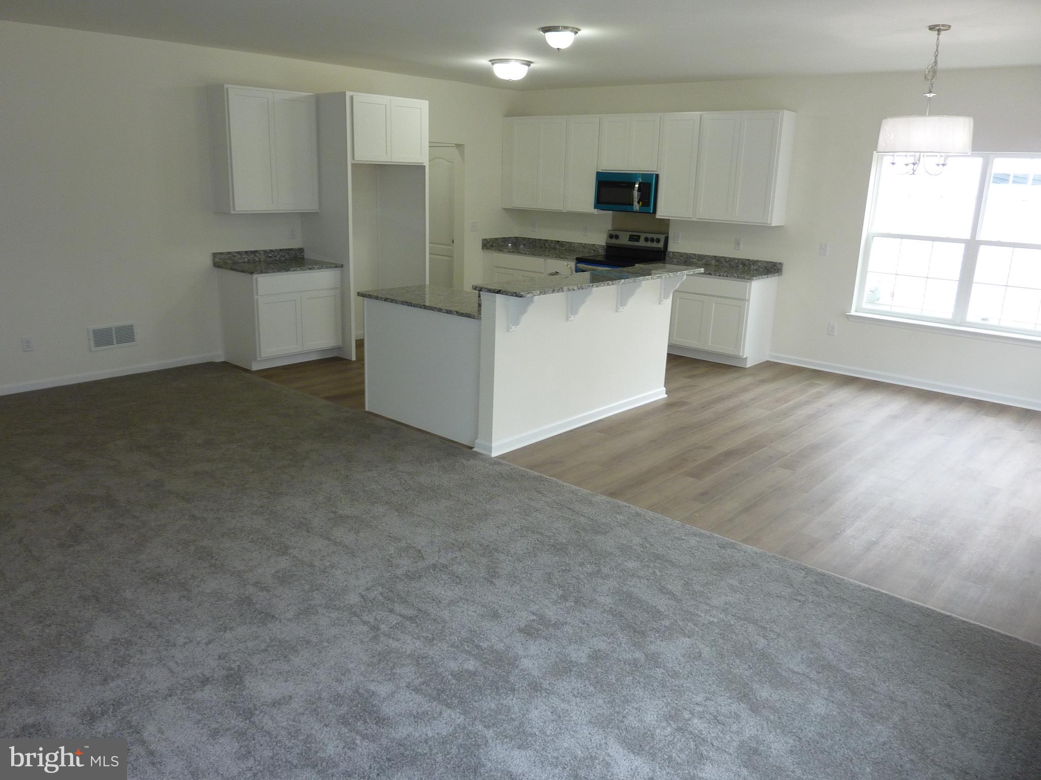 175 Villa Drive Clayton, DE 19938 - Photo 7 of 44 a kitchen with stainless steel appliances a stove top oven a sink a refrigerator and white cabinets