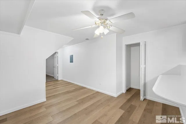 an empty room with wooden floor and staircase