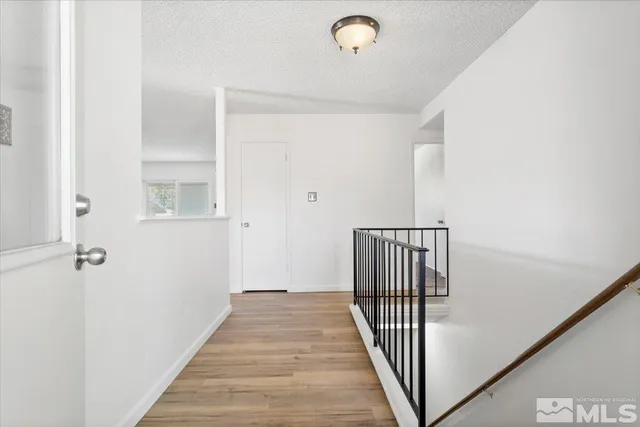 a view of a hallway with wooden floor and staircase