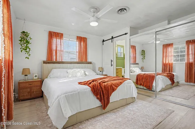 a bedroom with a large bed and a chandelier