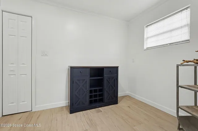 a view of an empty room and room with wooden floor