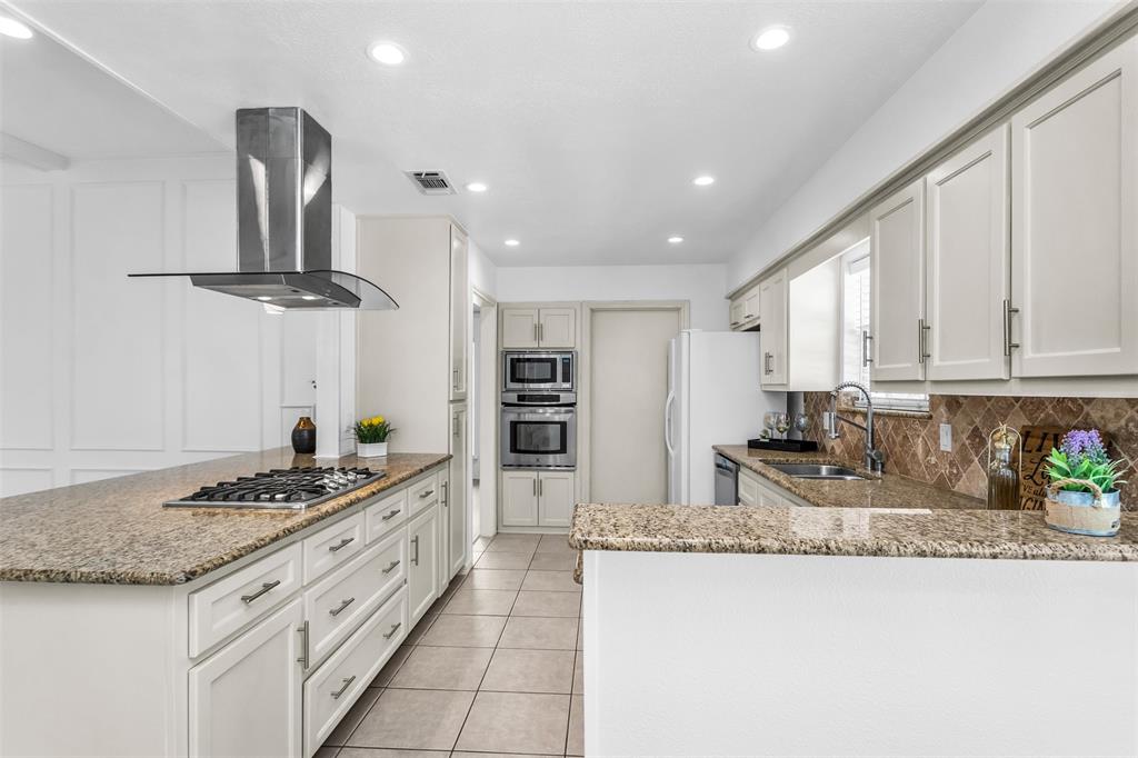 7233 Rustic Valley Drive Dallas, TX 75248 - Photo 10 of 21 a kitchen with stainless steel appliances granite countertop a sink stove and refrigerator