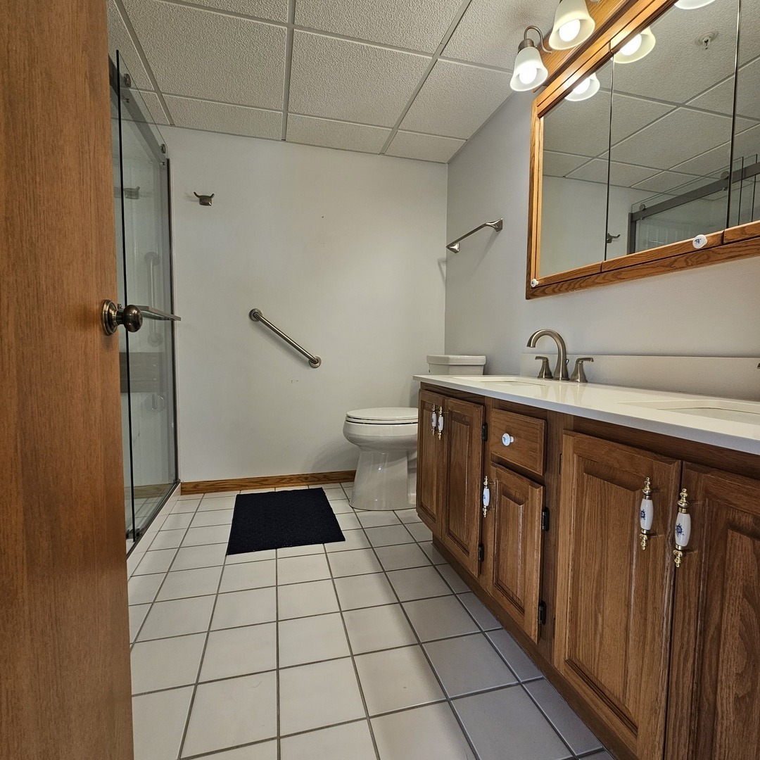 3620 186th Street, Unit 405 Lansing, IL 60438 - Photo 31 of 36 a bathroom with a sink a toilet and mirror